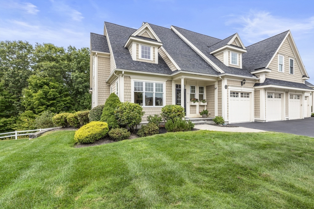 a view of a white house with a big yard and potted plants