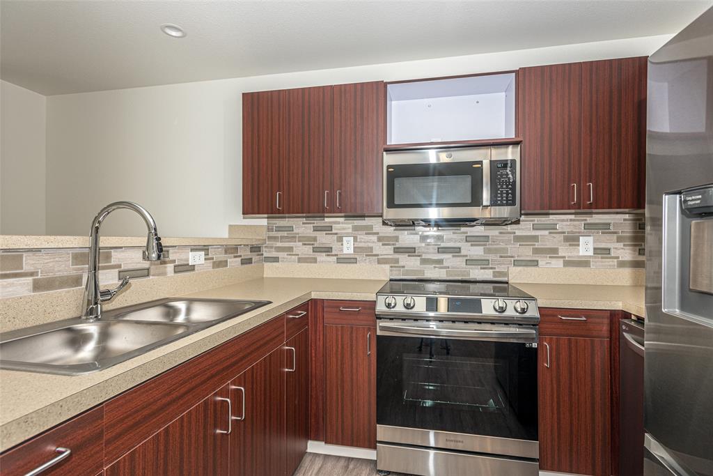 a kitchen with a sink stove and microwave