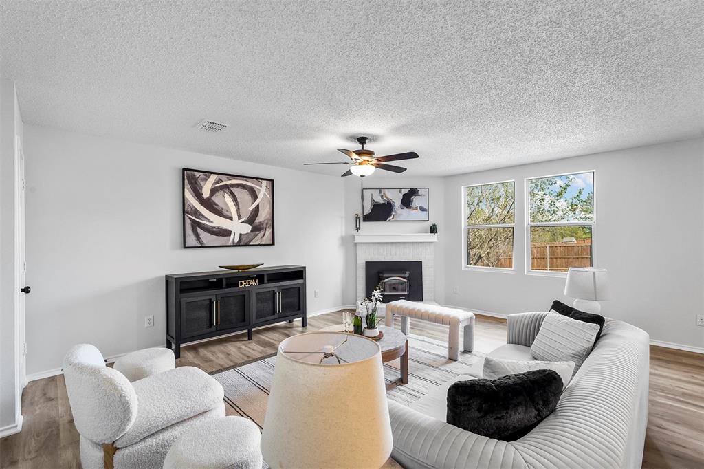 a living room with furniture a fireplace and a window