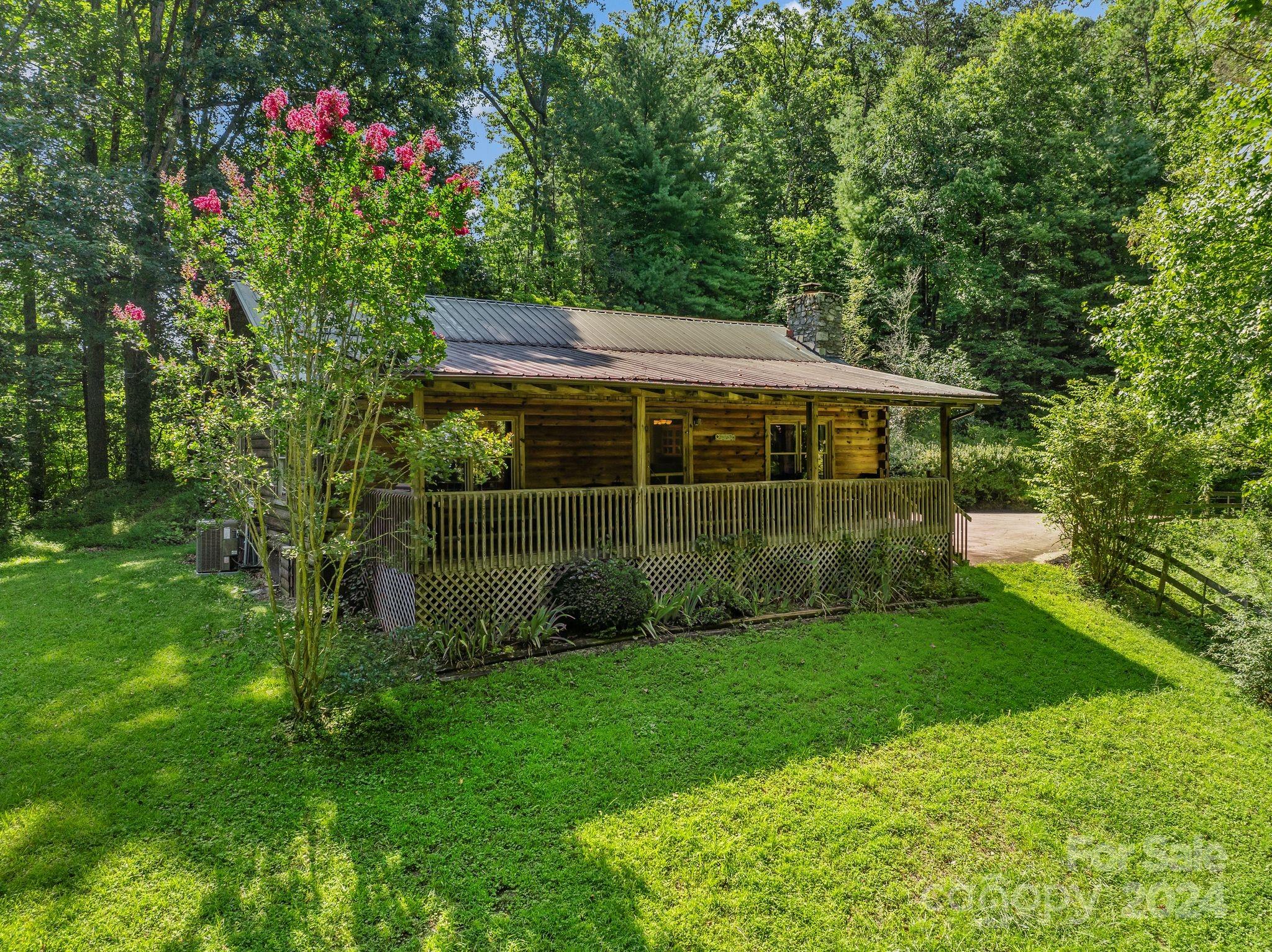 a view of house with a big yard and potted plants