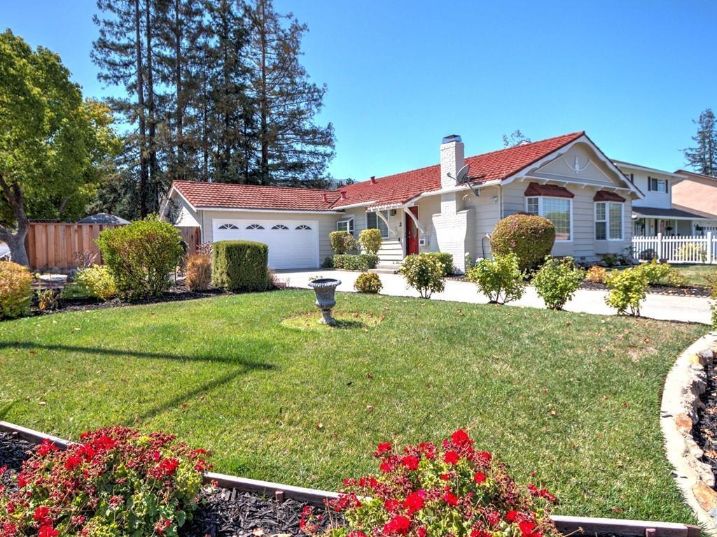 a front view of a house with a big yard and potted plants