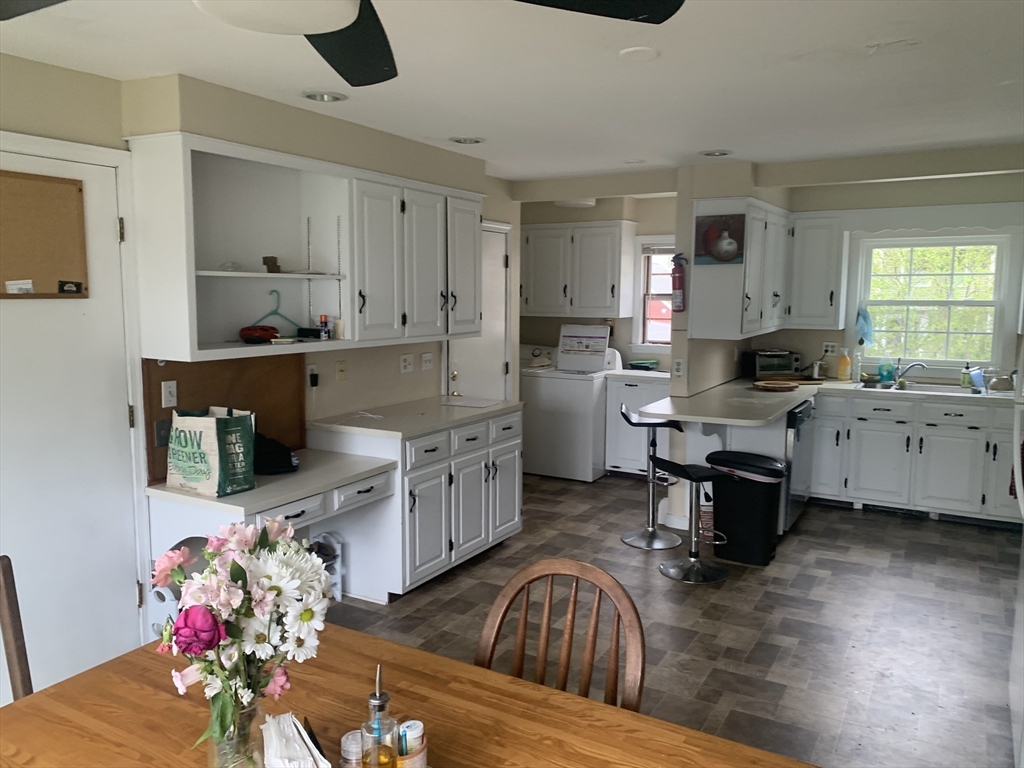 a living room with furniture kitchen view and a wooden floor