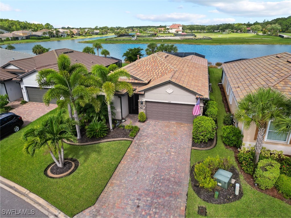 an aerial view of a house with outdoor space and lake view in back yard