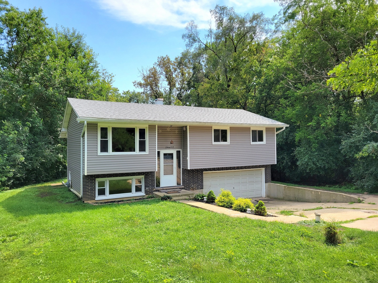 a front view of house with yard and green space