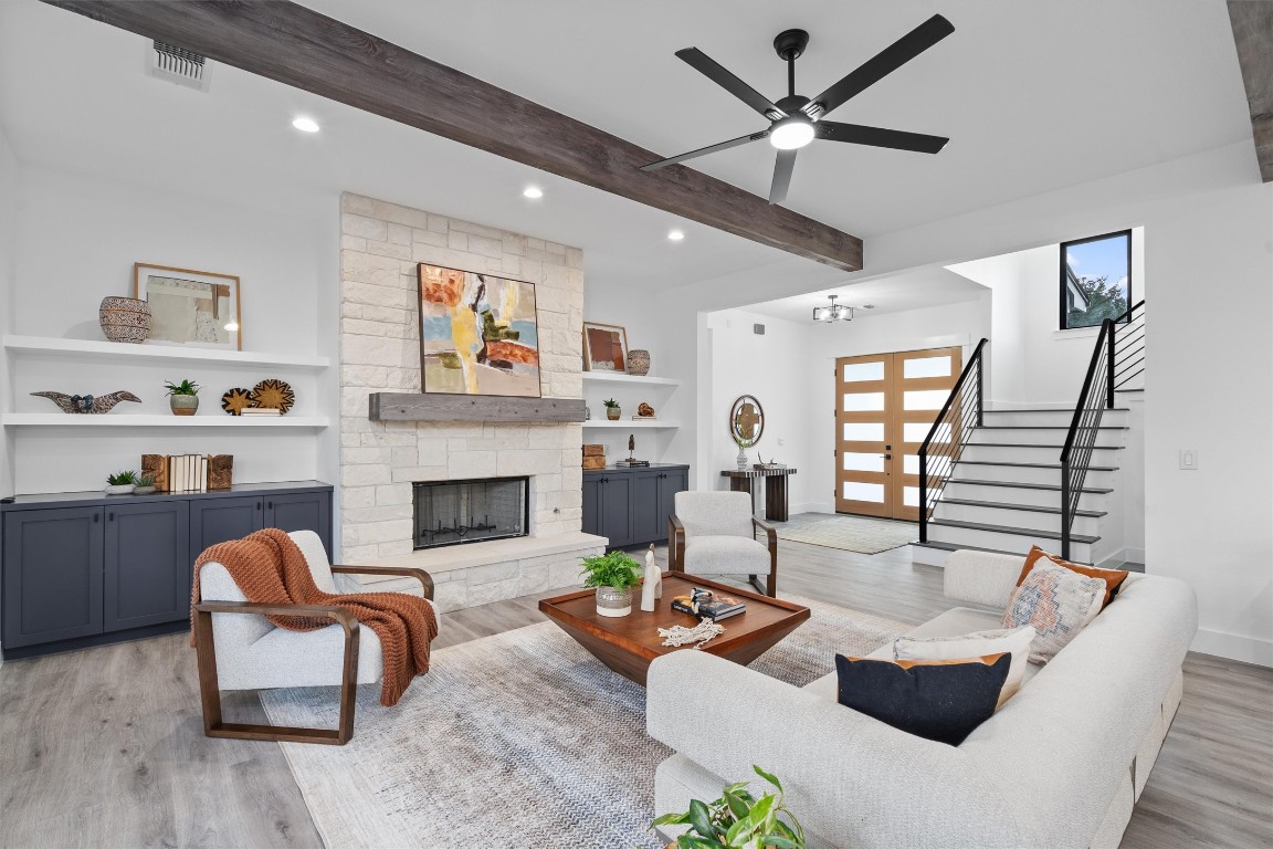 a living room with furniture a fireplace and a chandelier