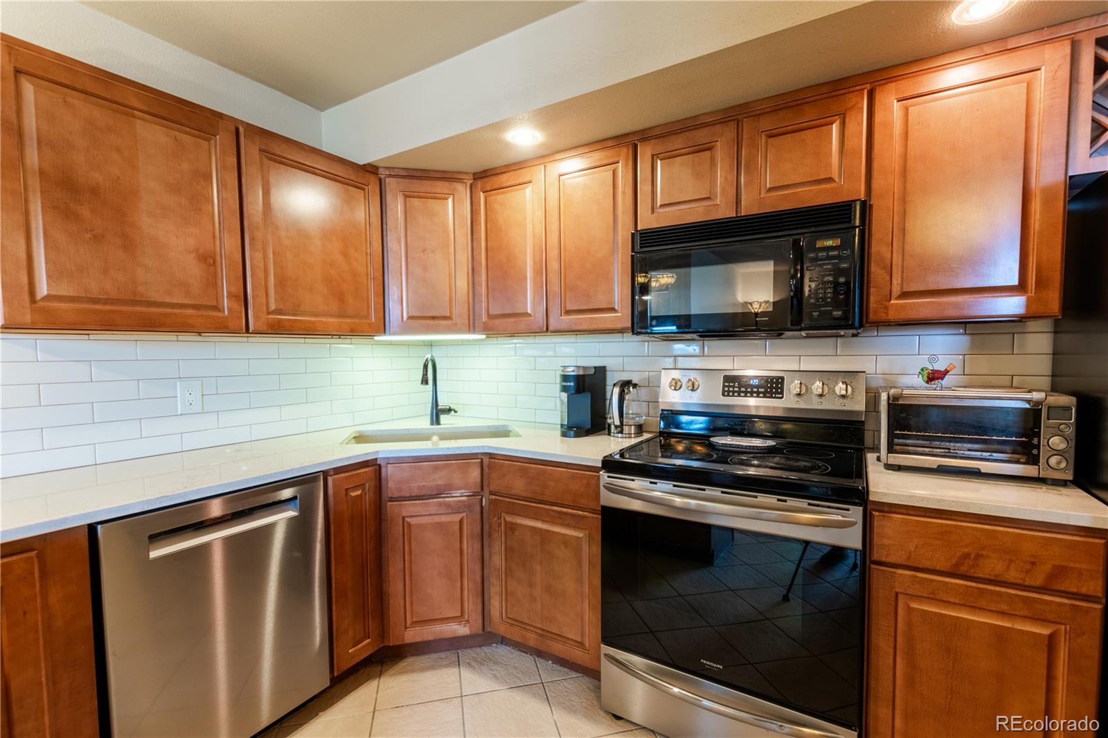 a kitchen with stainless steel appliances granite countertop a stove microwave sink and cabinets