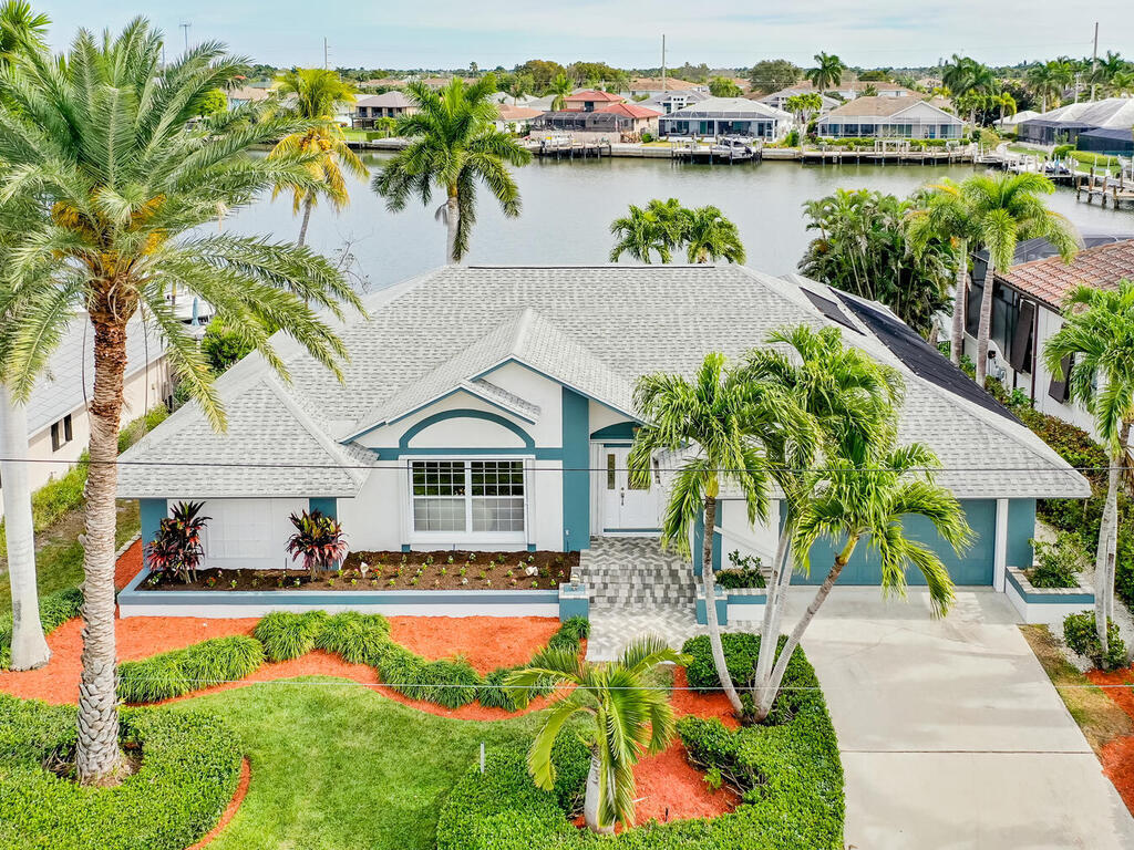 an aerial view of a house with a yard and lake view