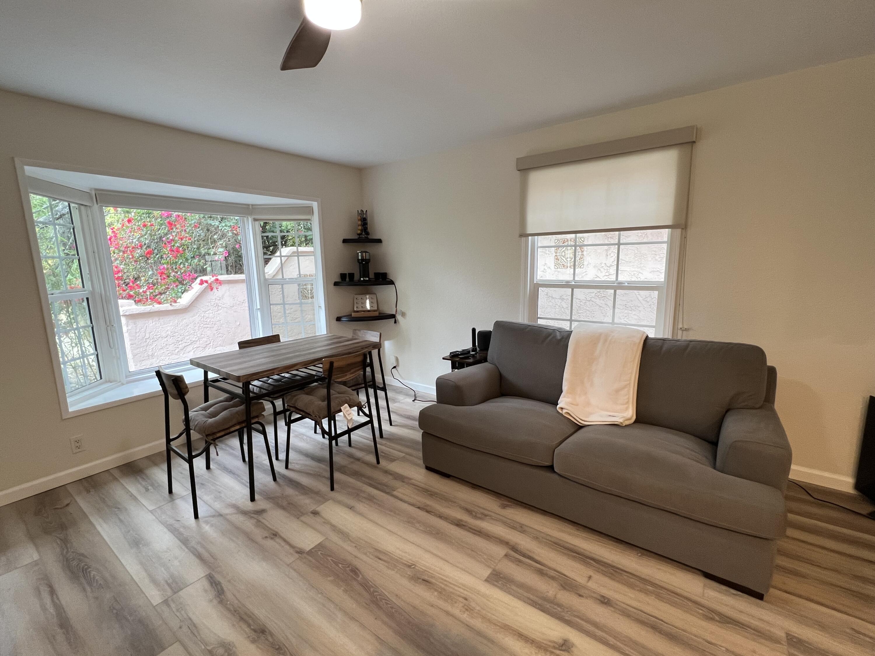 a living room with furniture a desk and chair with wooden floor