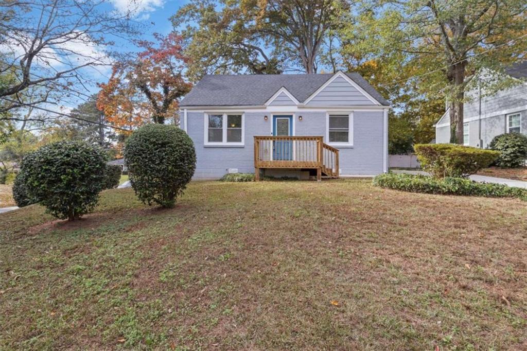 a front view of a house with a garden and trees