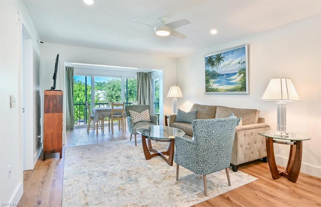 a living room with furniture a table and a large window