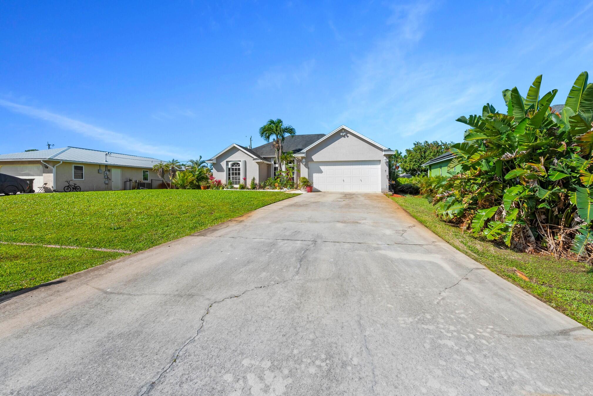 a view of a house with a yard and large trees