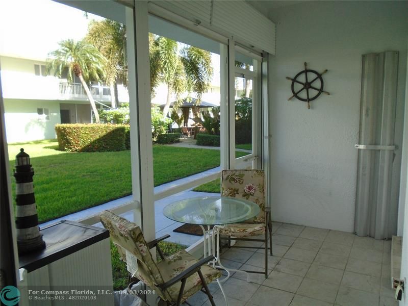 a view of a porch with chairs and backyard