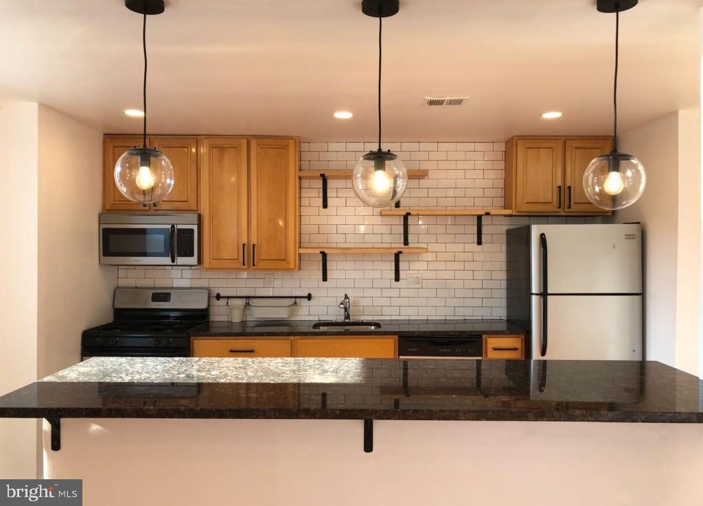 a kitchen with a refrigerator a sink and a table