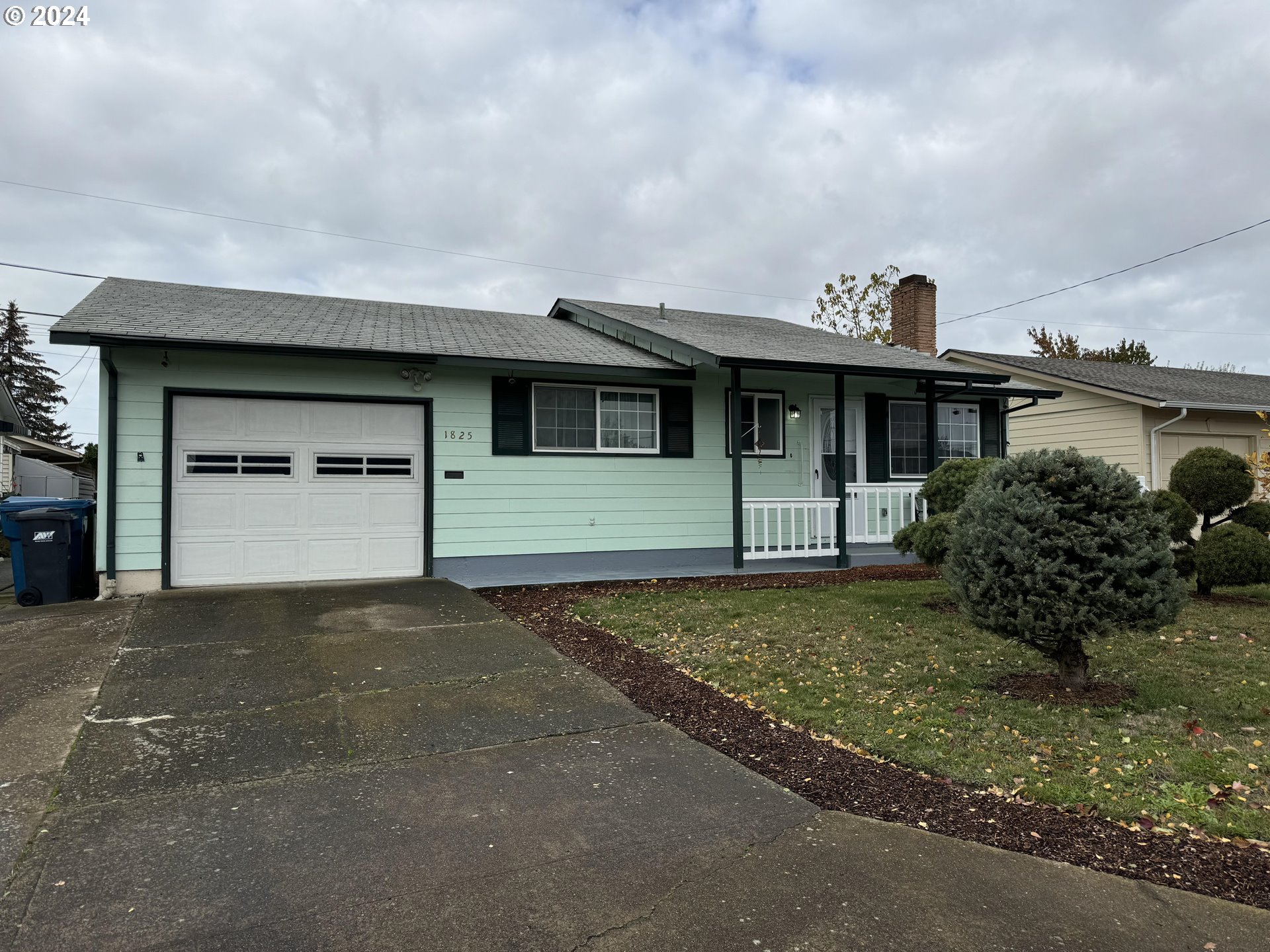 a front view of a house with a garden and garage