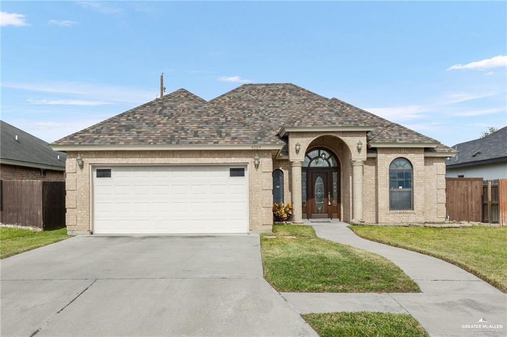 a front view of a house with yard and parking