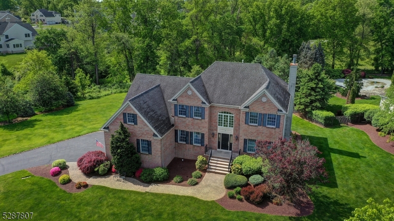 a aerial view of a house next to a big yard and large trees