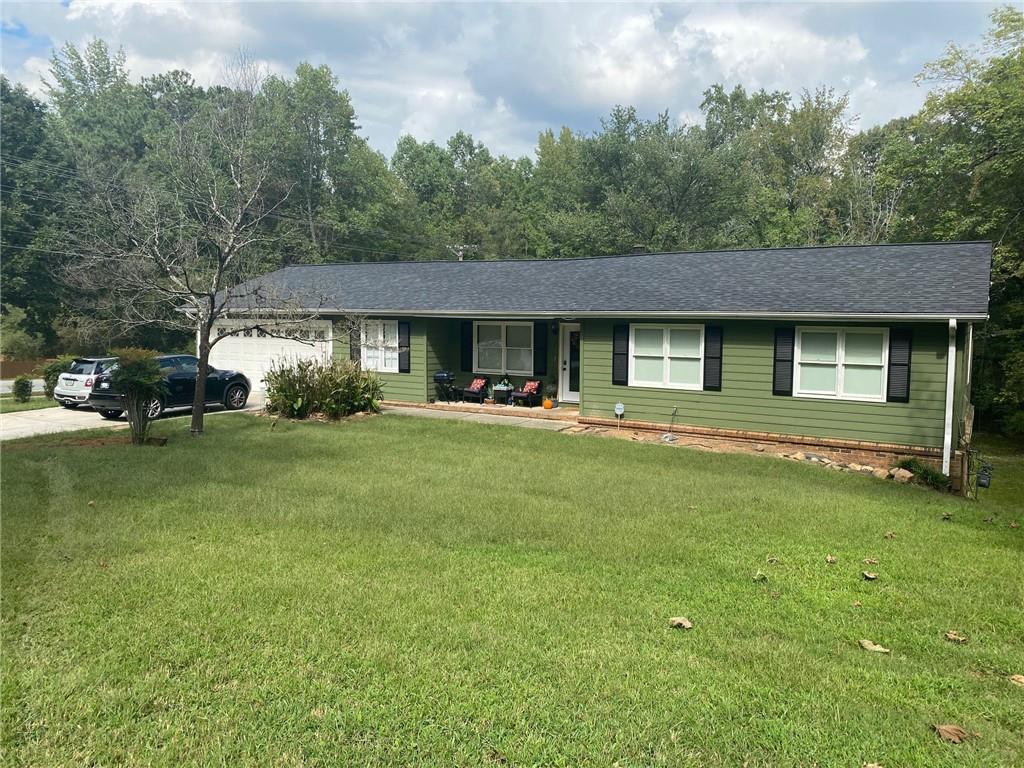 a front view of a house with a garden and trees