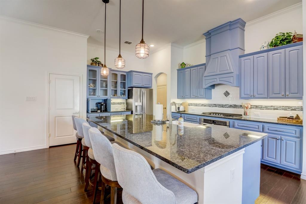 a kitchen with granite countertop a sink a center island and stainless steel appliances