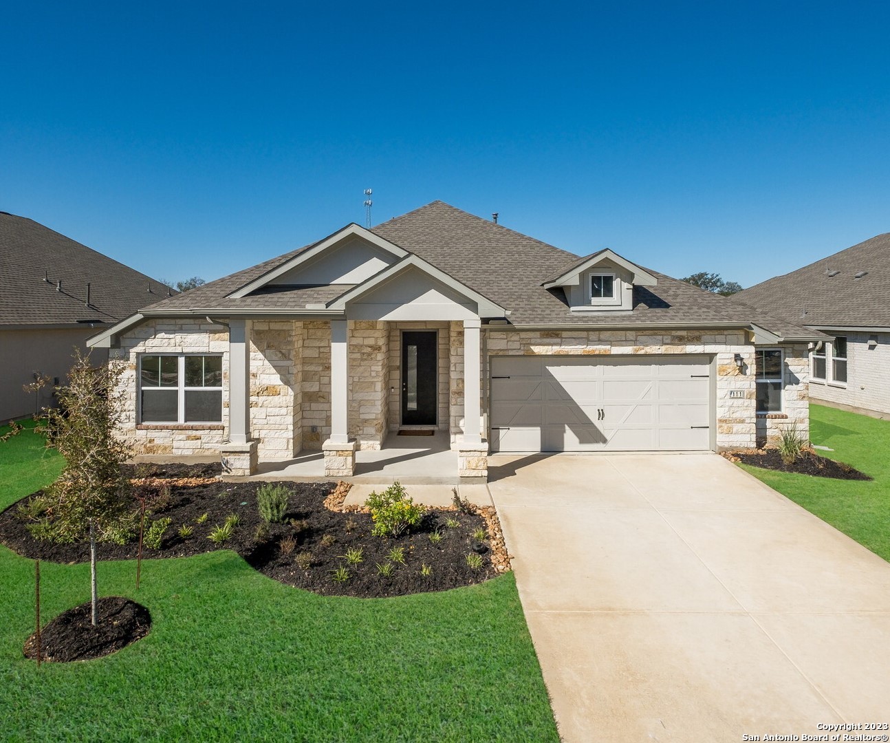 a front view of a house with a garden and yard