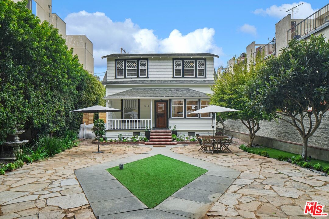 a patio with table and chairs and potted plants