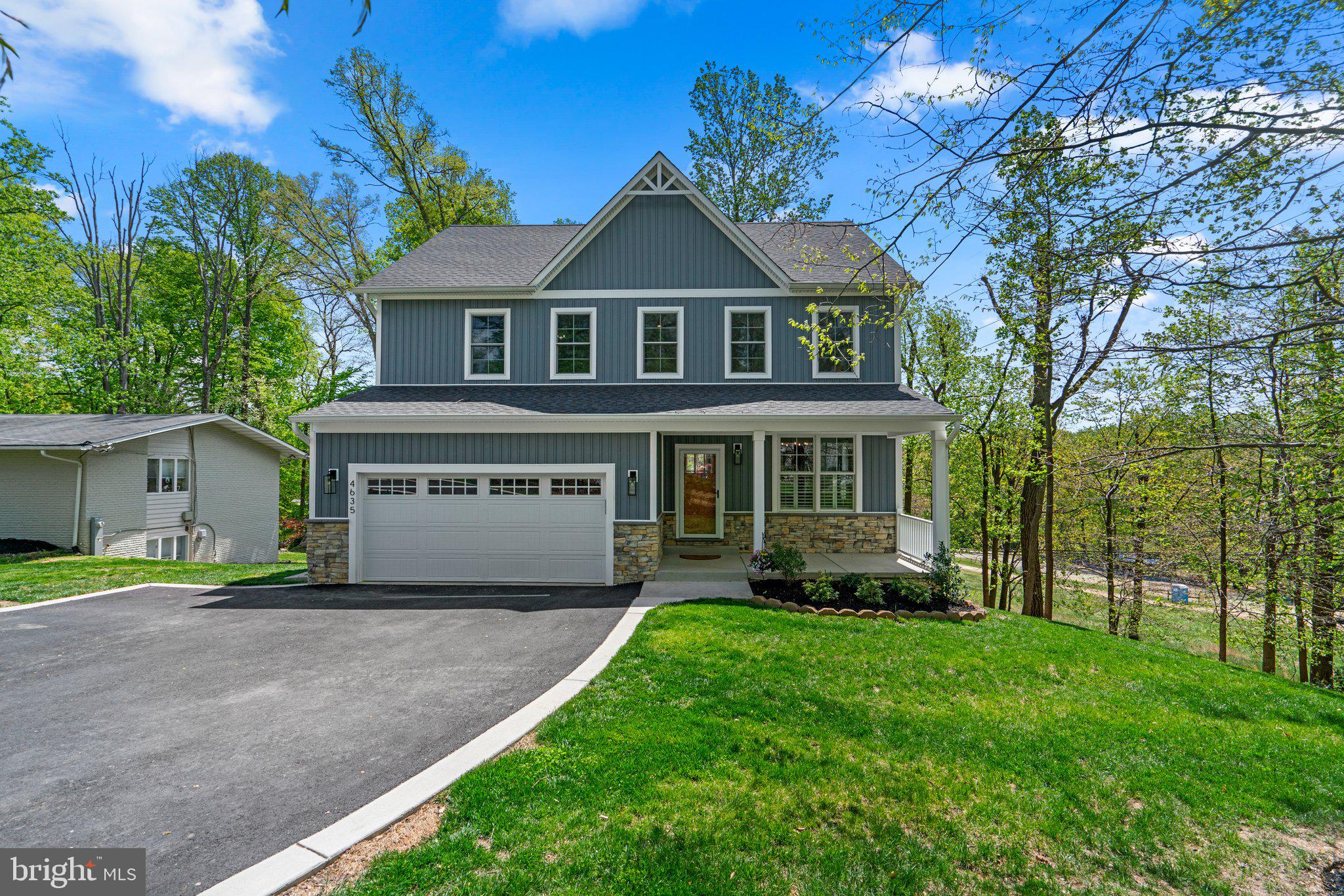 a front view of a house with a yard and trees