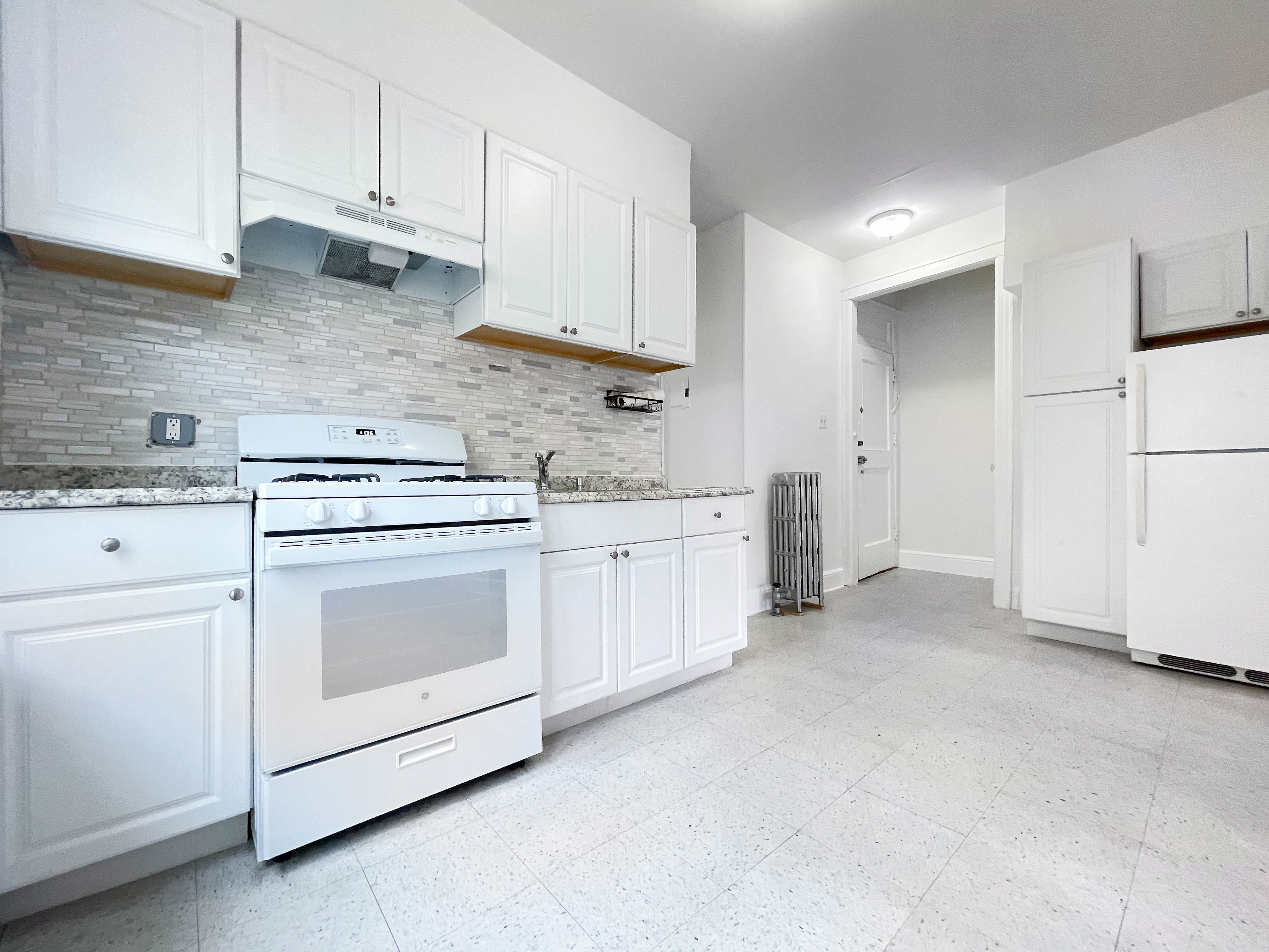 a kitchen with white cabinets and white appliances