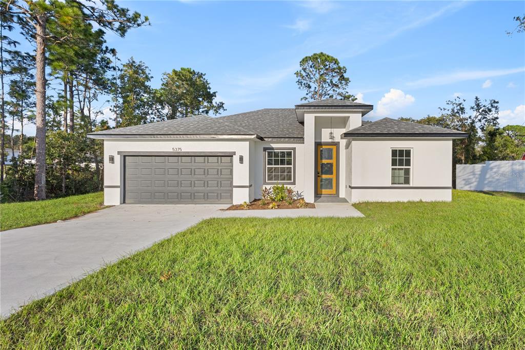 a front view of a house with a yard and garage