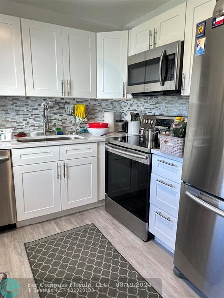 a kitchen with granite countertop cabinets stainless steel appliances and a sink