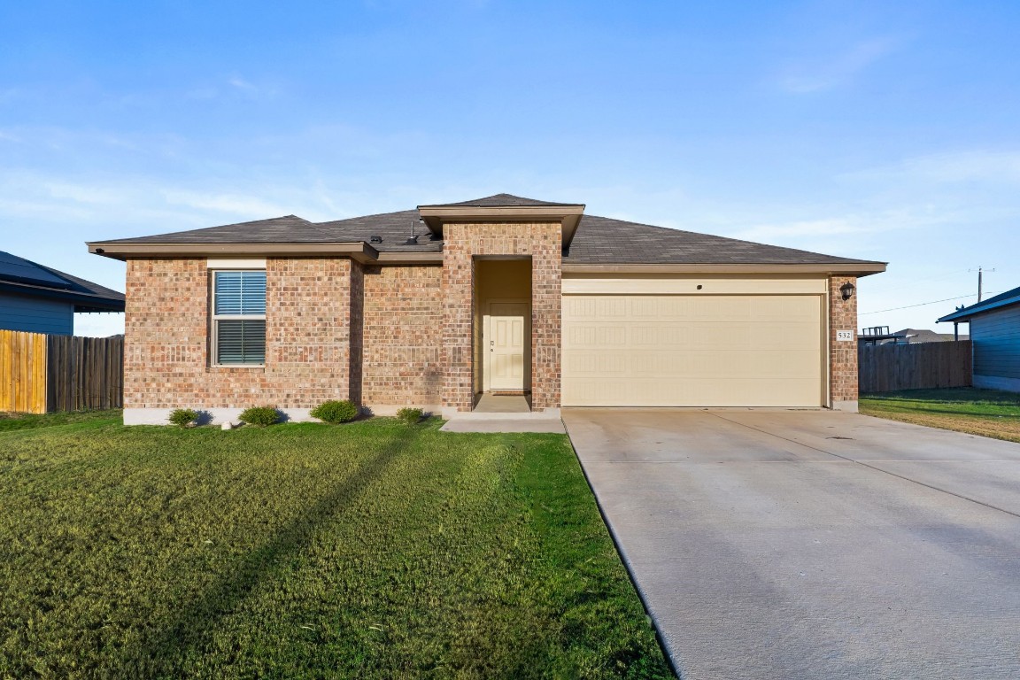 a front view of a house with a yard and garage