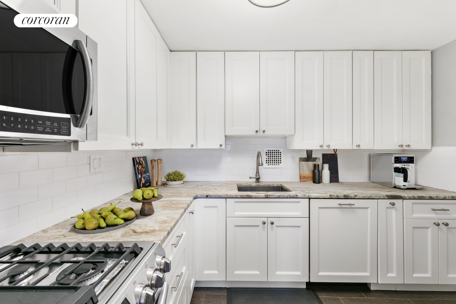 a kitchen with granite countertop white cabinets and stainless steel appliances