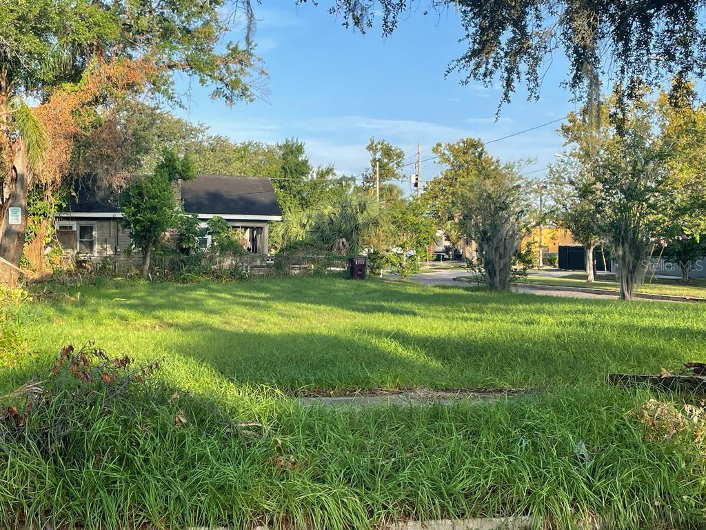 a view of a fountain in front of a house with a big yard