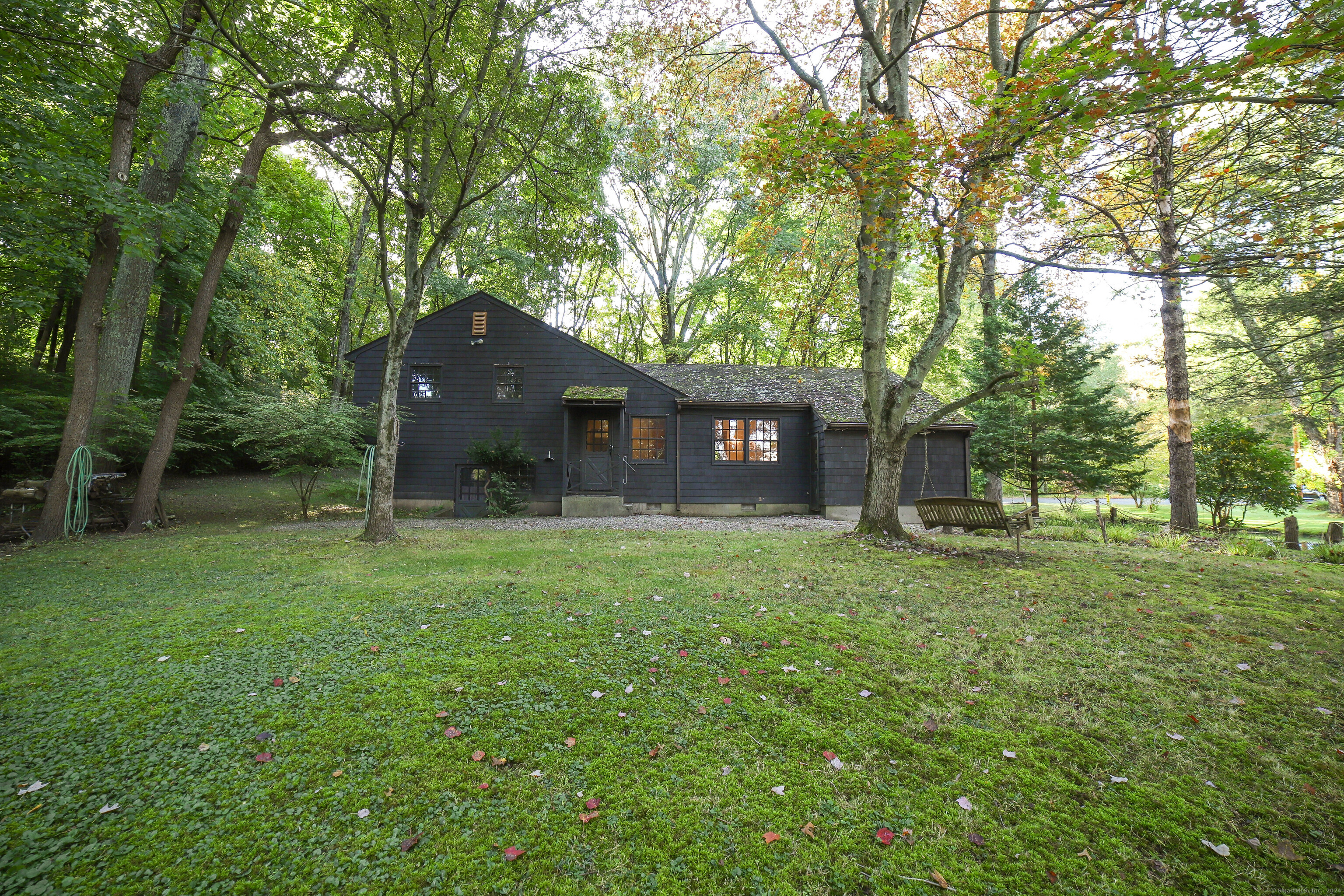 a front view of a house with a garden and trees