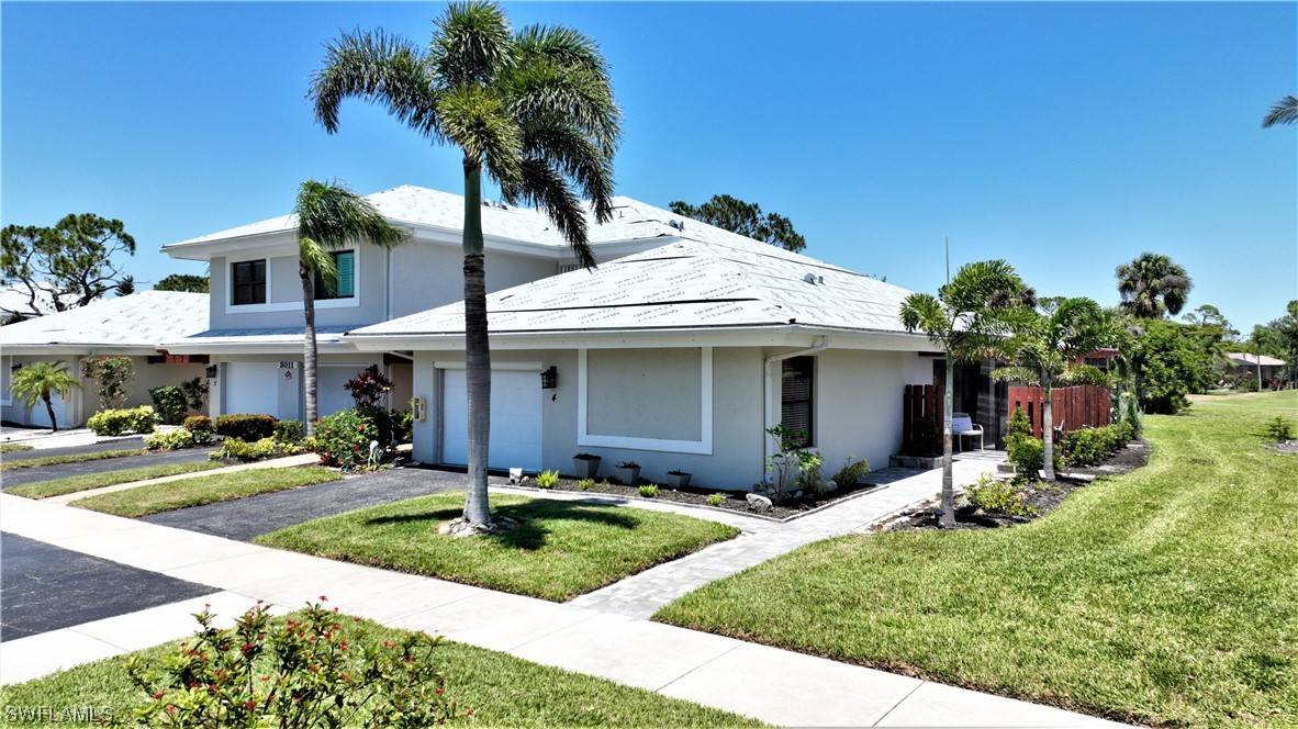 a front view of a house with a yard and potted plants