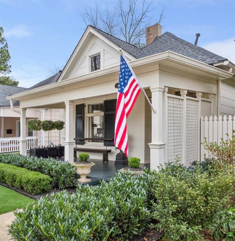 a view of a white house with a small yard and potted plants