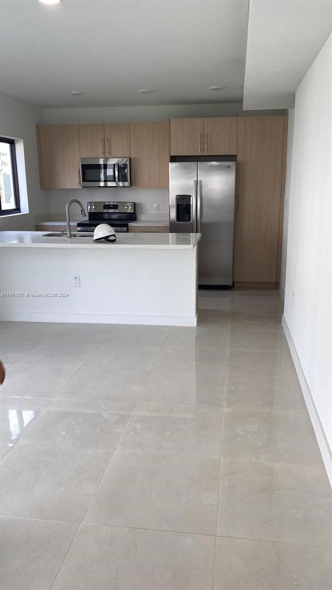 a large kitchen with cabinets and stainless steel appliances