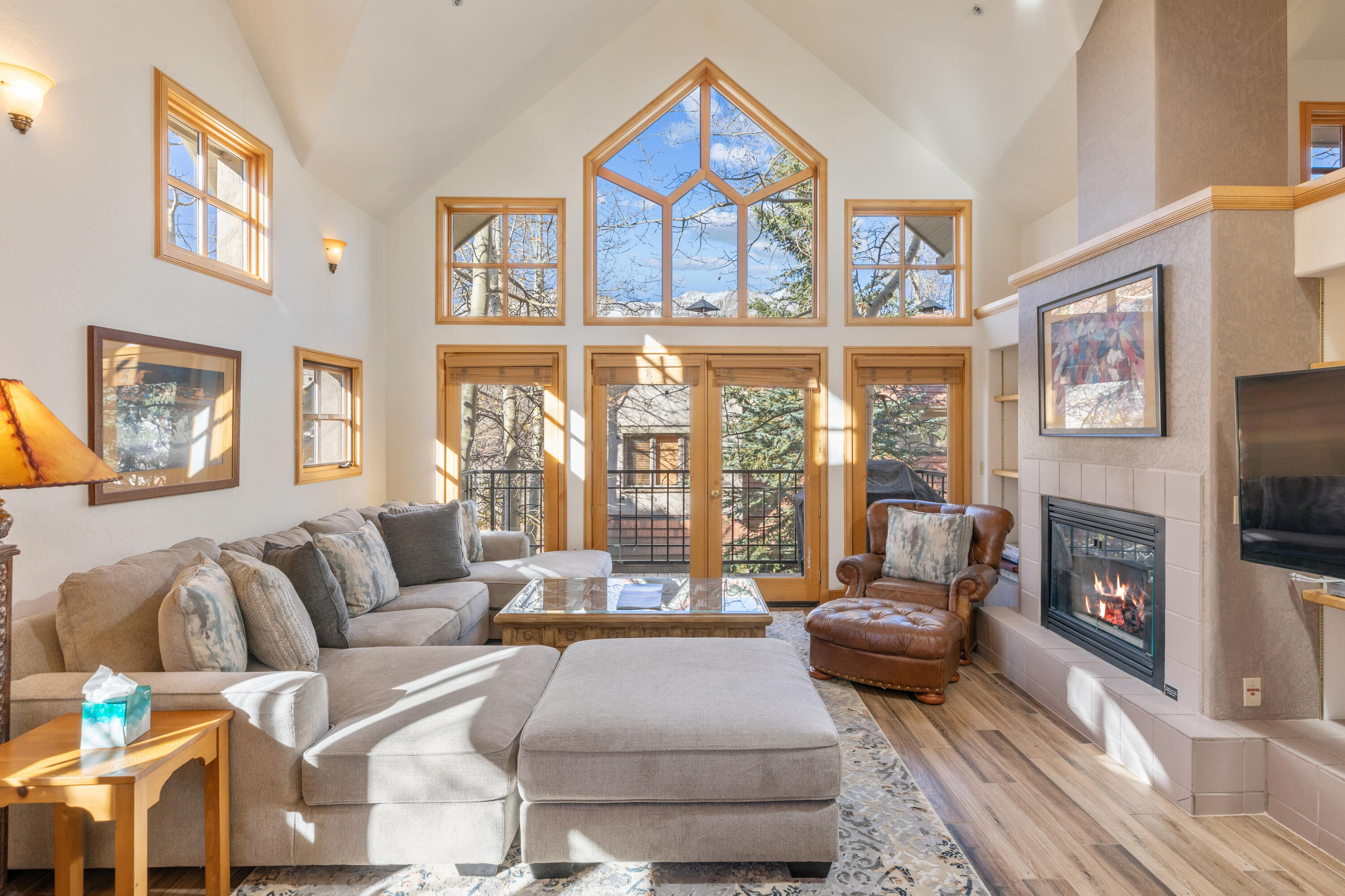 a living room with furniture large window and a fireplace