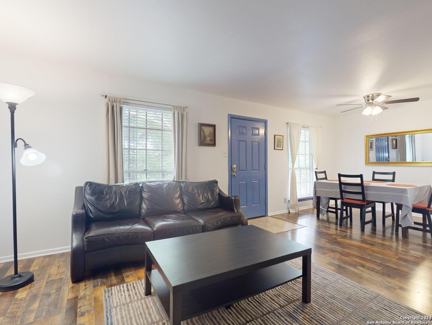 a living room with furniture and a wooden floor