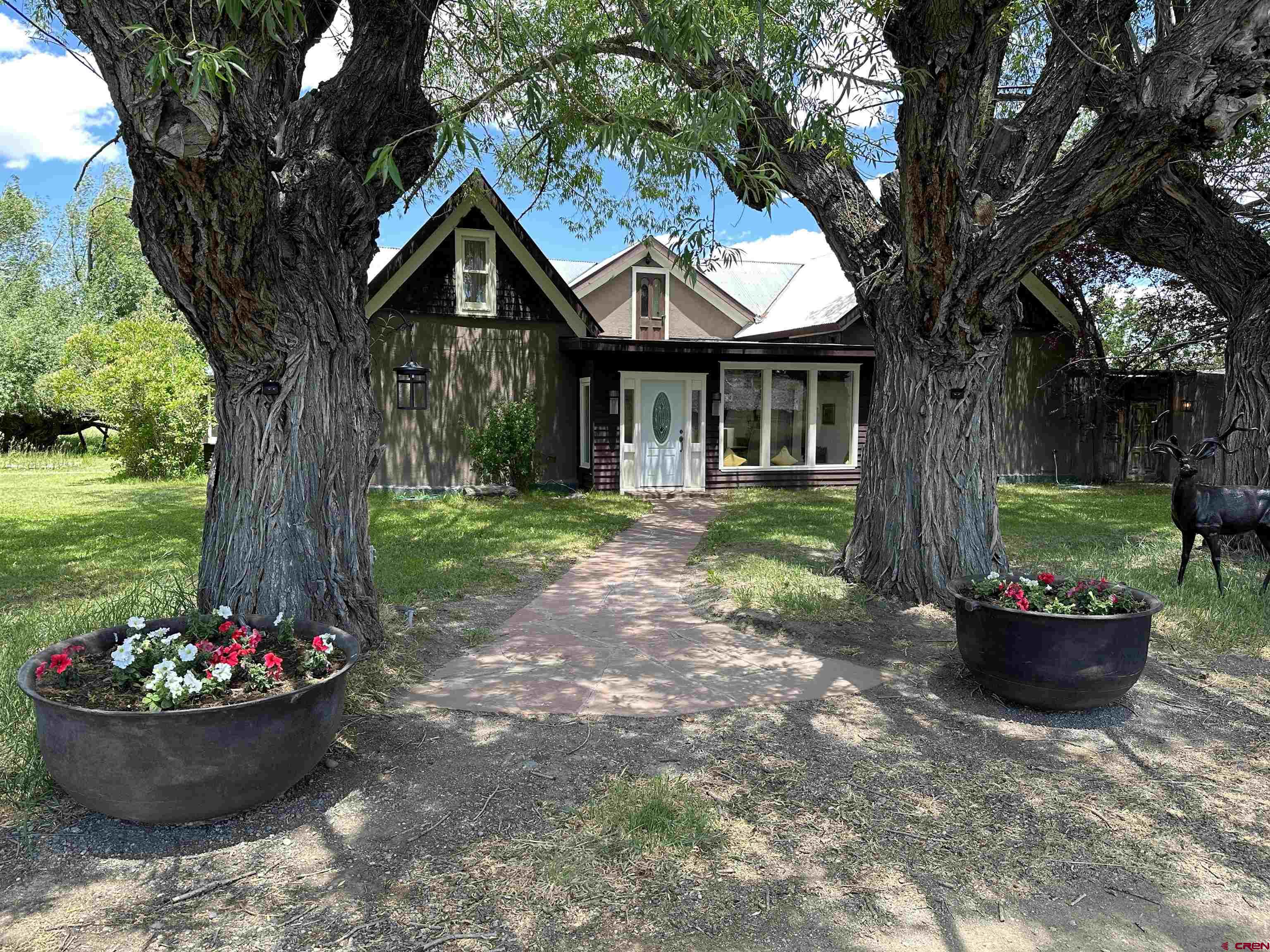 a front view of a house with a yard and a fountain