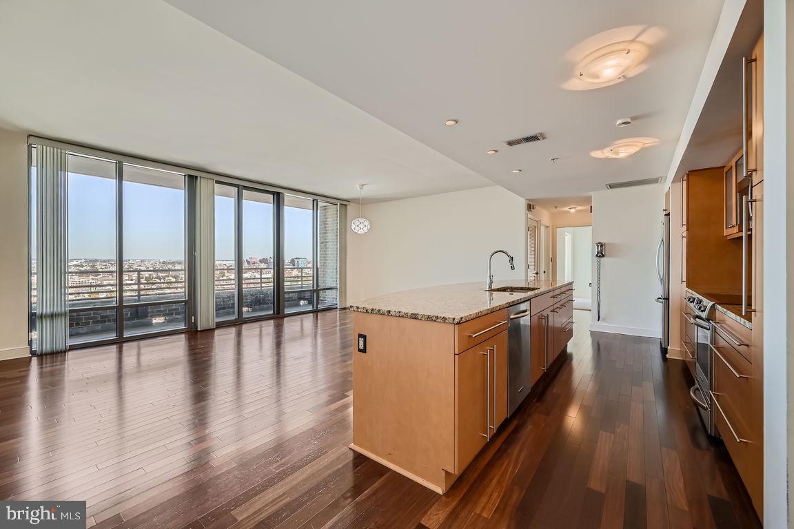 a large kitchen with a large window a sink and stainless steel appliances