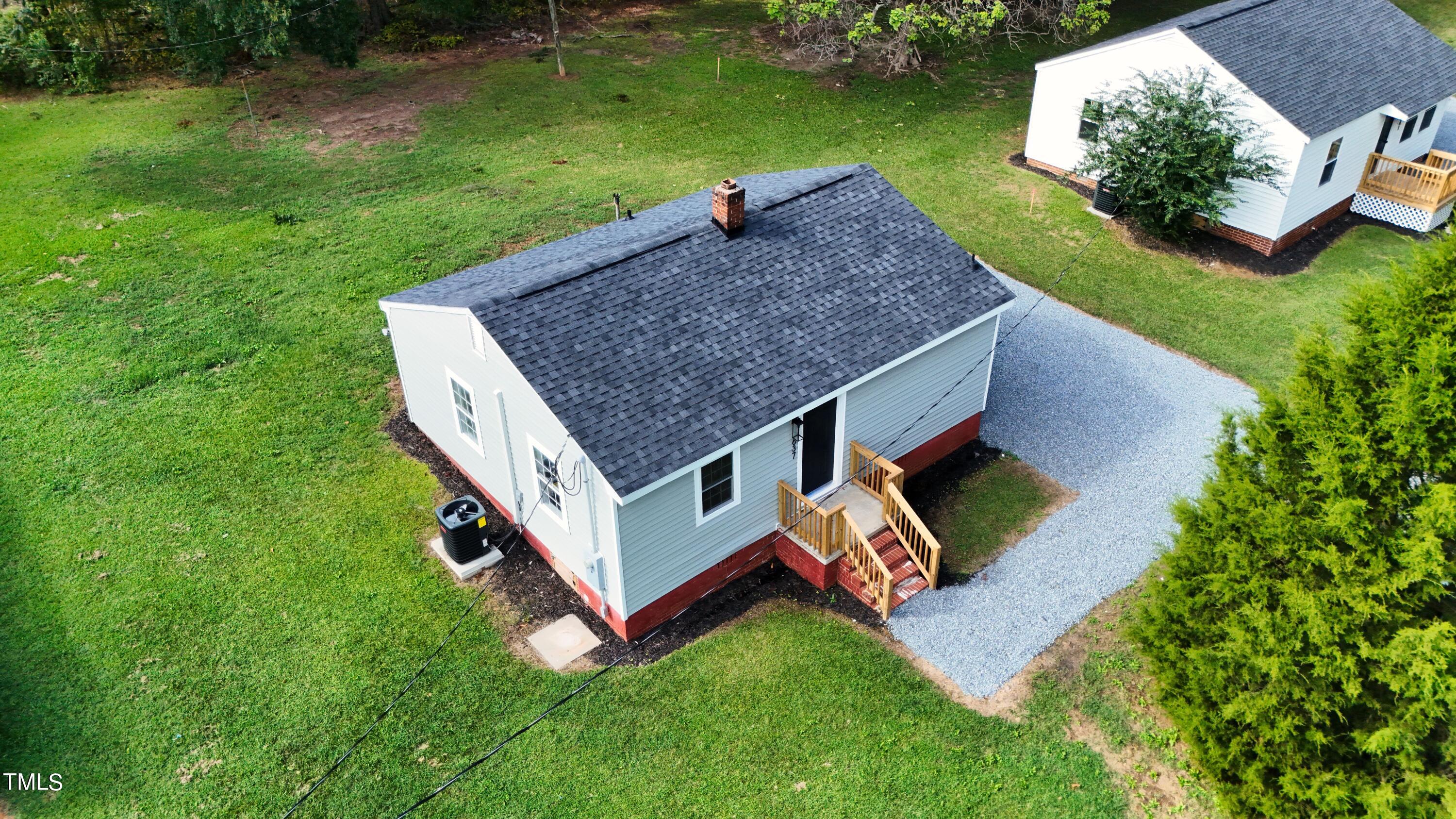 an aerial view of a house with swimming pool and garden