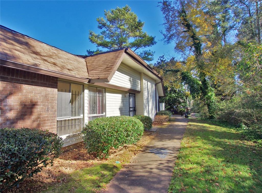 a view of a house with a small yard and floor to ceiling window