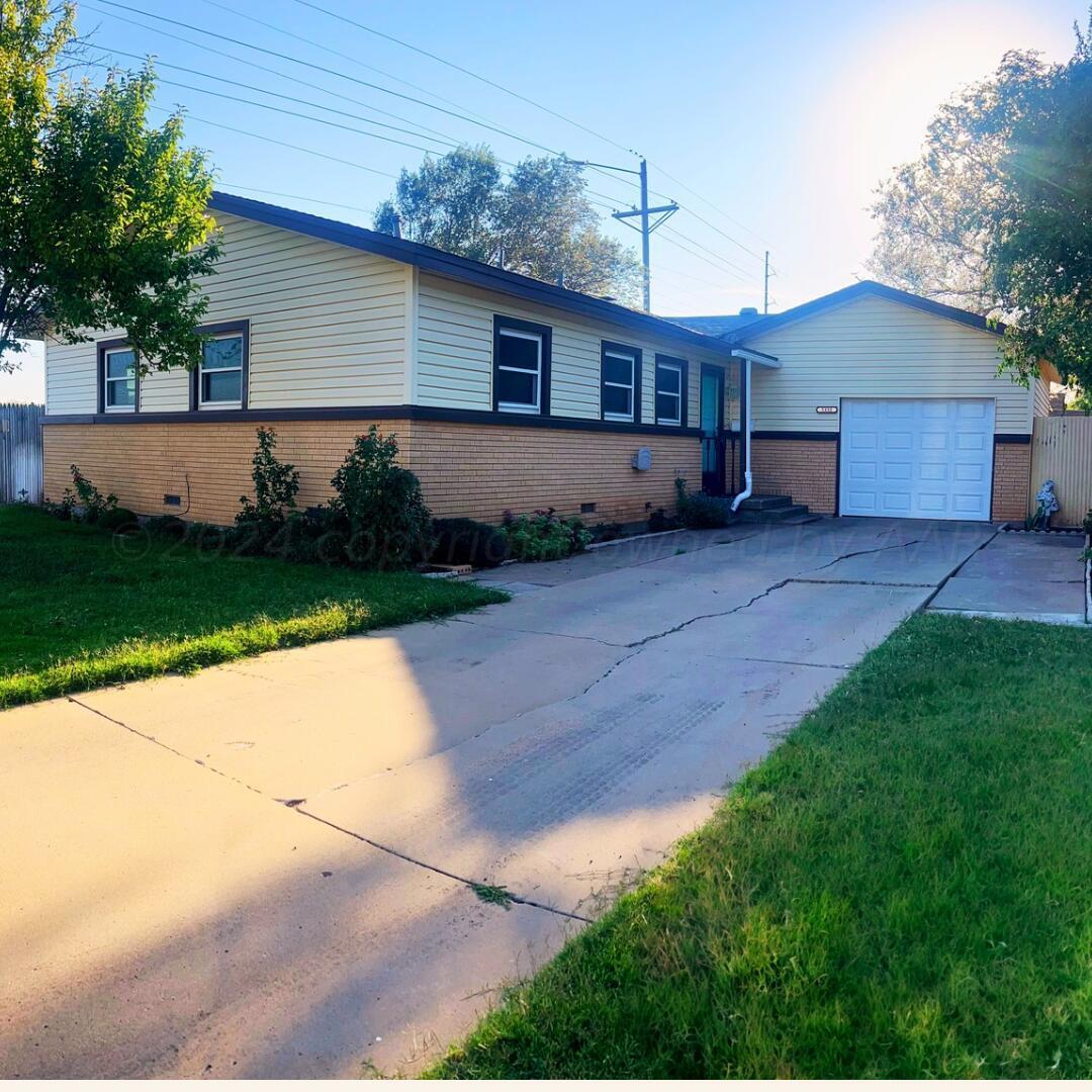 a front view of house with a yard and green space