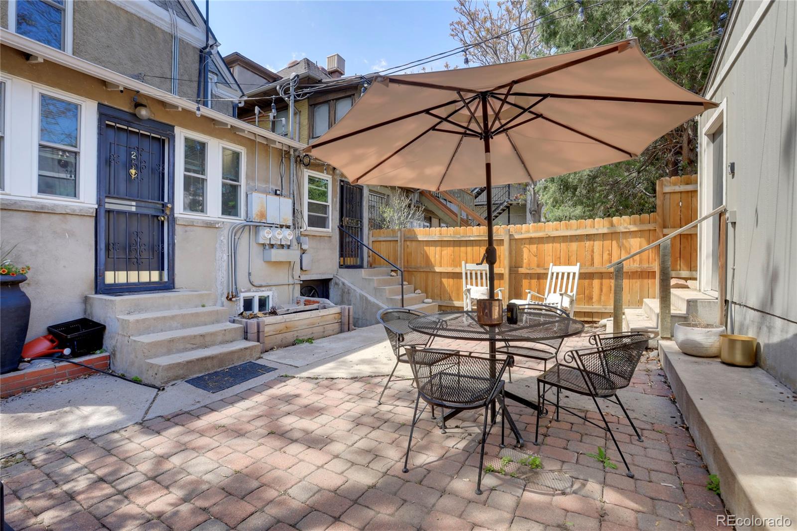 a view of a patio with a table and chairs under an umbrella