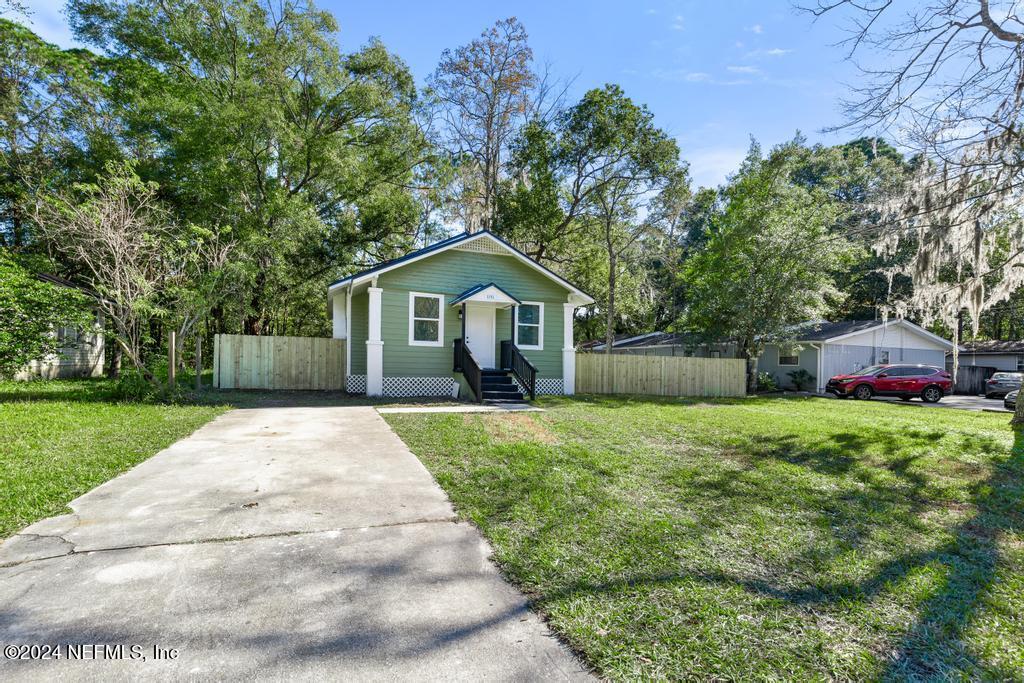 a front view of a house with a yard and trees