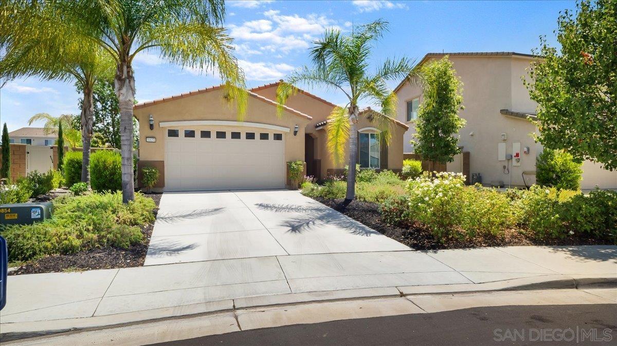 a view of a house with a small yard and palm trees