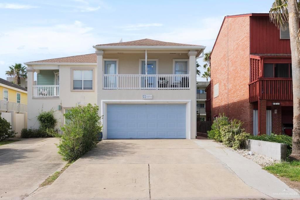 View of front facade featuring a garage and a balcony