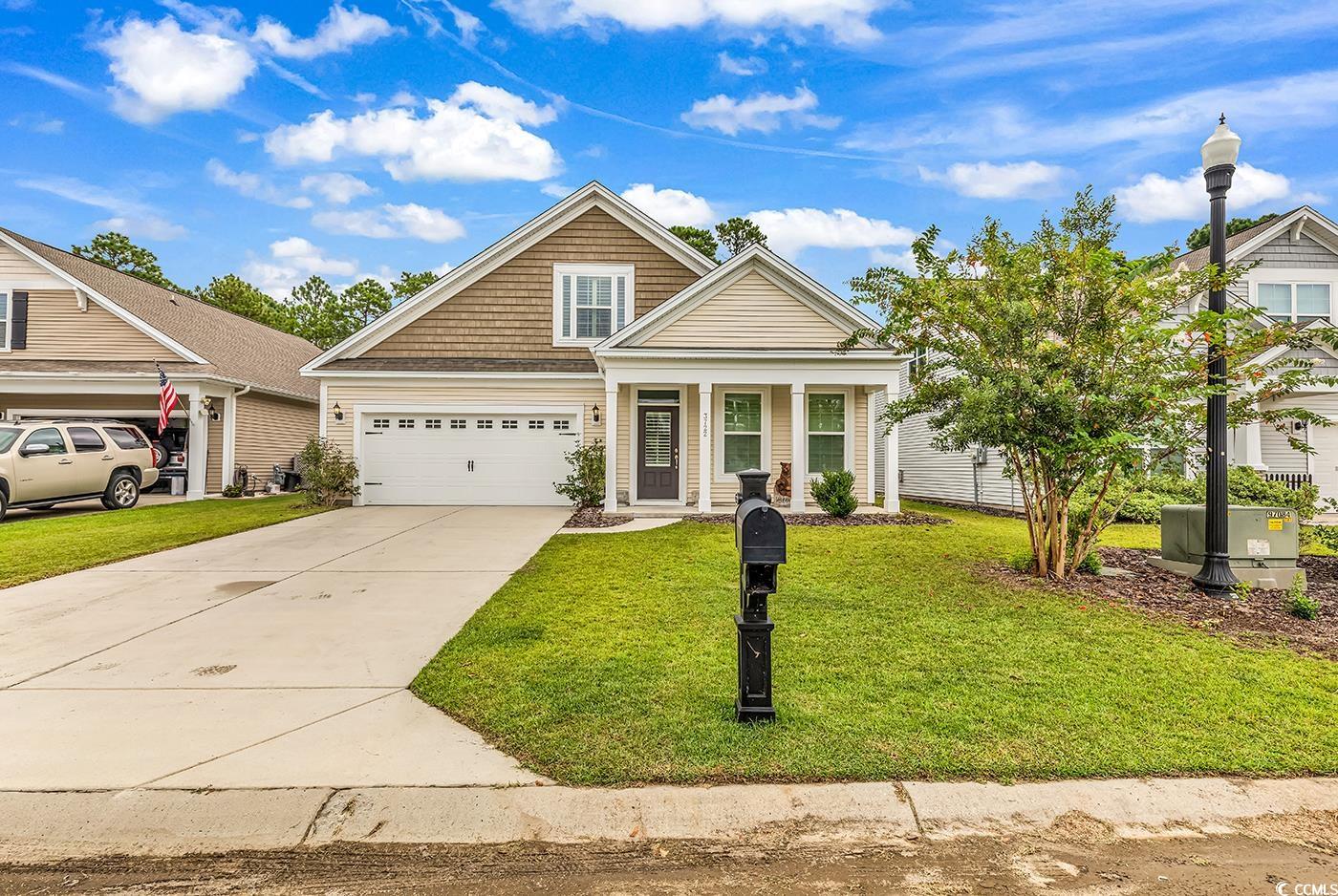 View of front of home with a front lawn and a gara