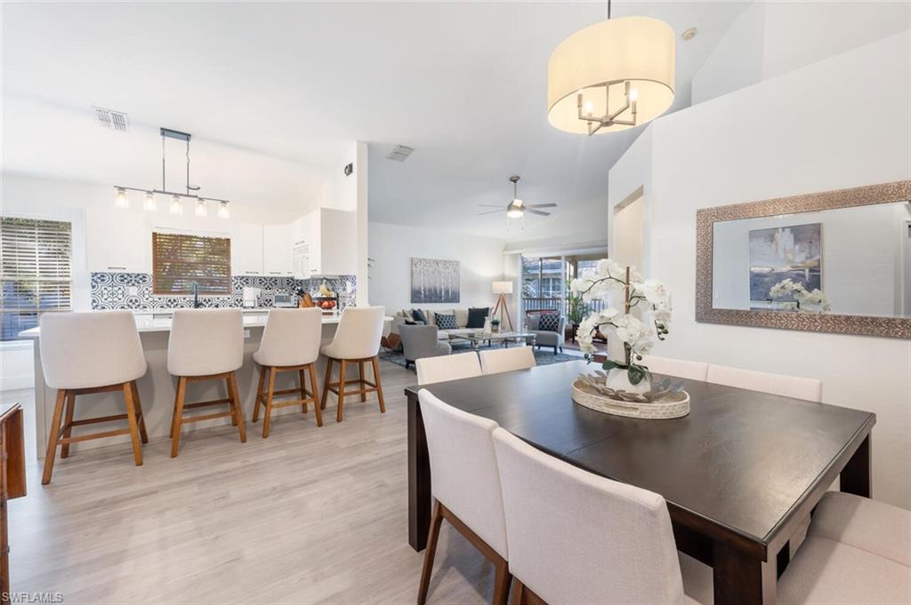 a dining room with wooden floor a chandelier a wooden table and chairs