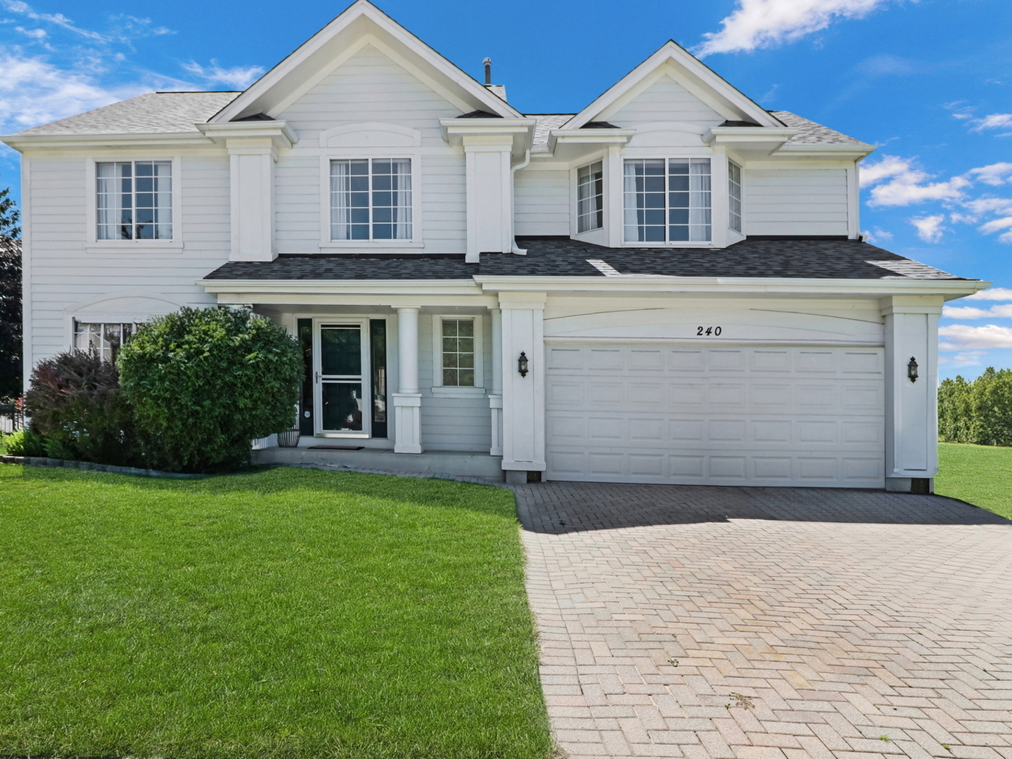 a front view of a house with a garden and yard