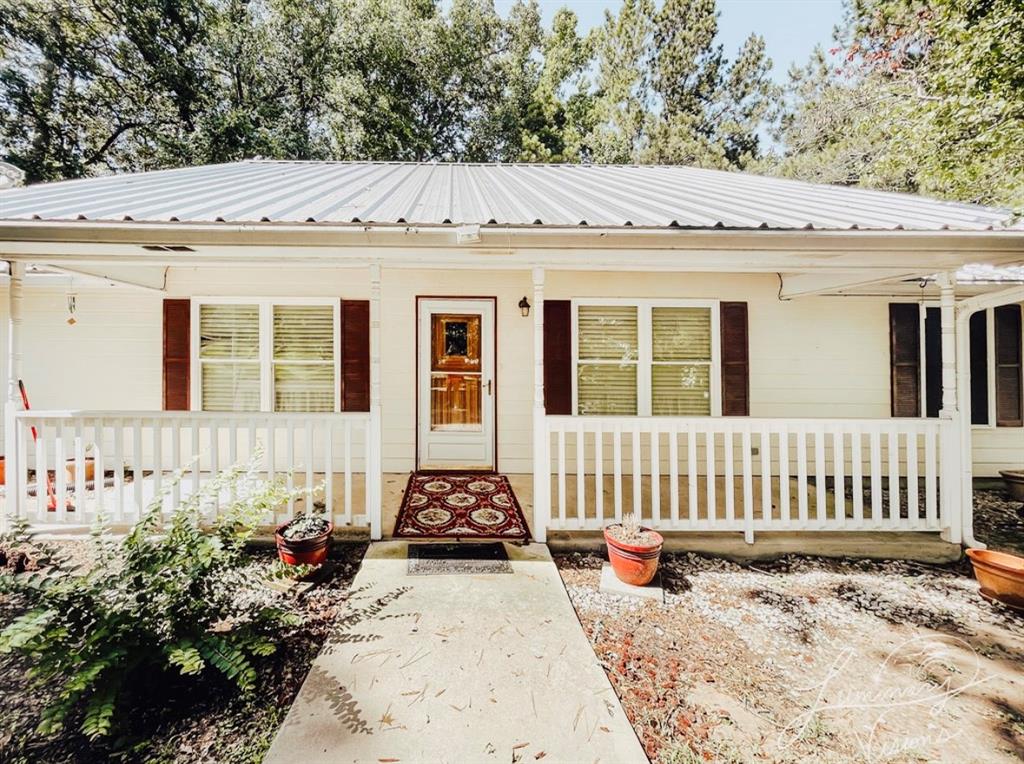 a view of a house with a wooden bench in a backyard